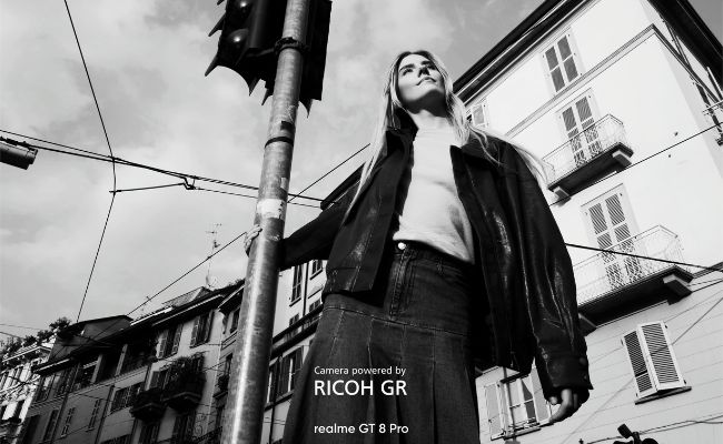 Photo de rue monochrome : une femme en extérieur, avec la mention "Camera powered by RICOH GR" et "realme GT 8 Pro".
